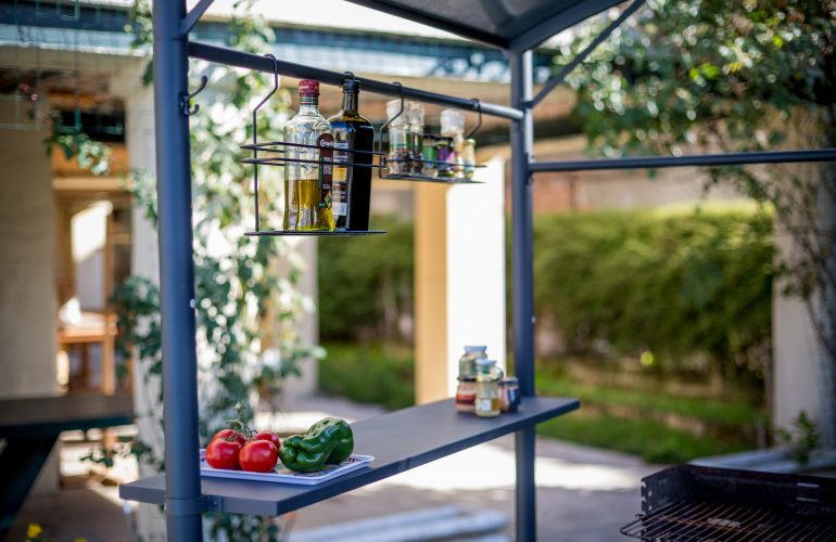 Espace barbecue bien organisé avec des étagères pour les condiments et les ustensiles, mettant en valeur un aménagement extérieur pour cuisiner en plein air par Bricomarché Cosne